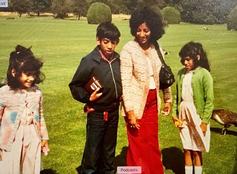 Grace on a lawn with her three young children.
